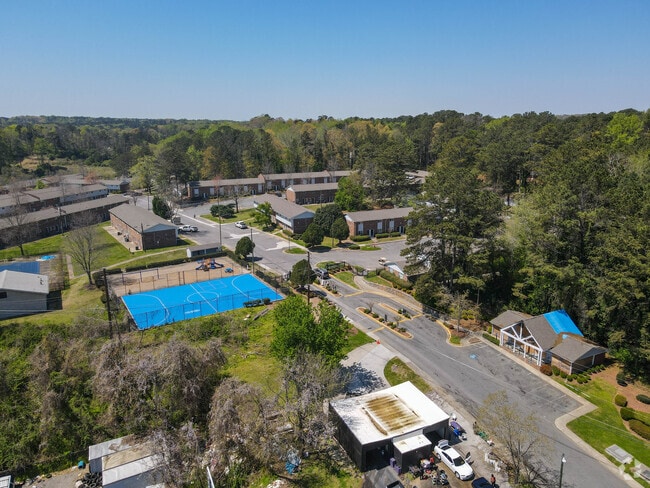 Aerial view of houses and a tennis court in a neighborhood.