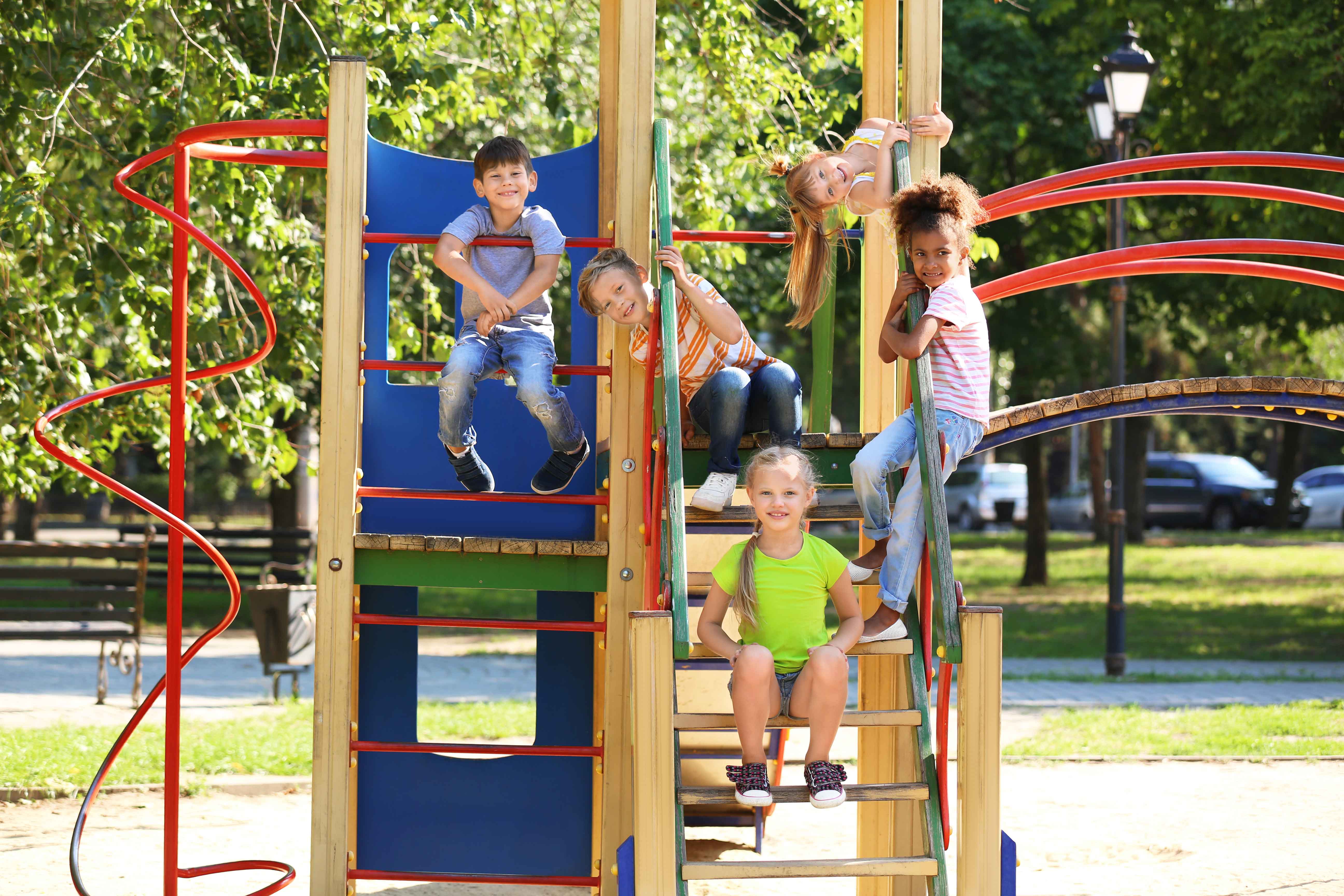 cute little children having fun on playground outdoors.